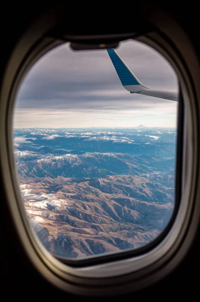日出时分 安第斯山脉被积雪覆盖在飞机窗上的景象 — 图库照片