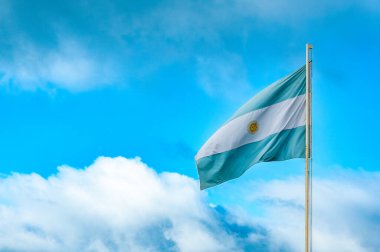 Açık mavi ve beyaz Arjantin bayrağı dalgalanıyor mavi gökyüzü ve arka plan olarak gri bulutlar