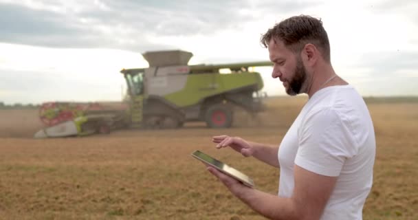 Agriculture Agronomist Stands Tablet Wheat Field Combine Works Background Combine — Stock Video