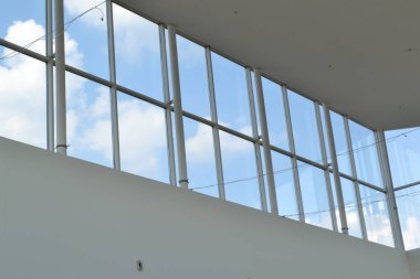 Alışveriş merkezinin cam pencereleri. Mavi gökyüzü. Beyaz duvarlar