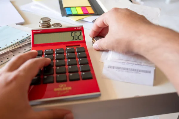 Hands of man with financial bills calculating with calculator