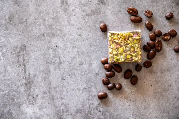 pistachio sweets with coffee beans on grey background