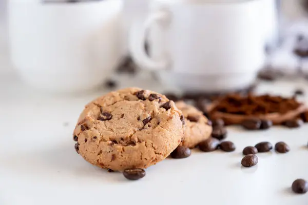 Two pieces of cookies with coffee set in the background
