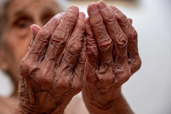 Old woman hands praying for god rising her hands