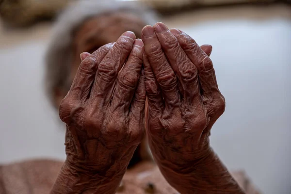 Old woman hands praying for god rising her hands