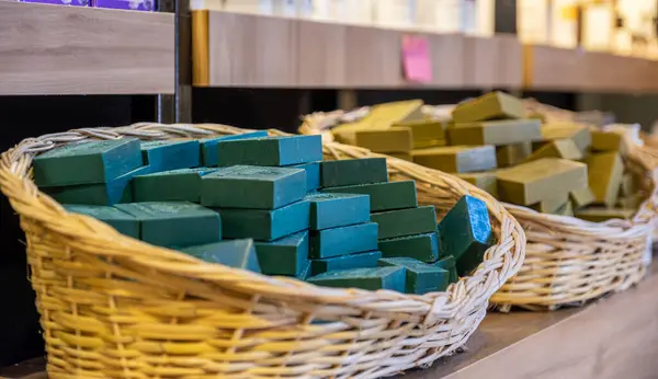 handmade basket full of handmade green soap in a store consist of body care products with wooden background