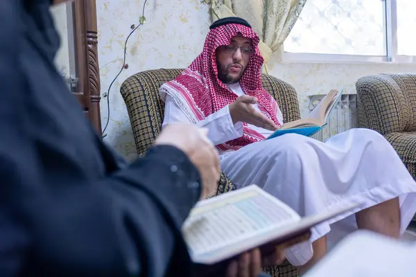 Muslim family reading a book while drinking coffee