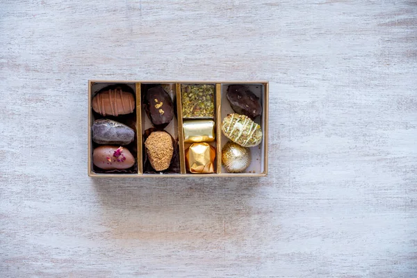 Top-View of Luxury Chocolate Box with Multiple Varieties in Stunning Golden Hues. Elegant Packaging with Copy Space. Perfect for Celebrations, Gifts, and Indulgent Occasions