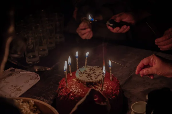A hand lights the birthday sparklers on the cake for the celebration