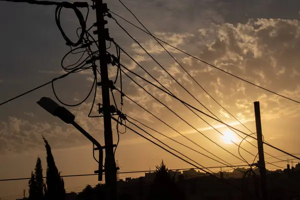 silhouette of electrical lines, fiber cables node and light at the golden hour