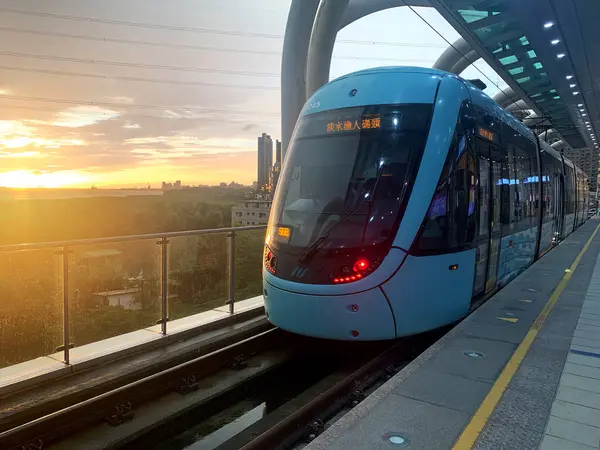 Gün batımında Tamsui Balıkçı İskelesi 'ne giden hafif raylı bir araç. Hongshulin hafif tren istasyonundan kalkmayı bekliyor..