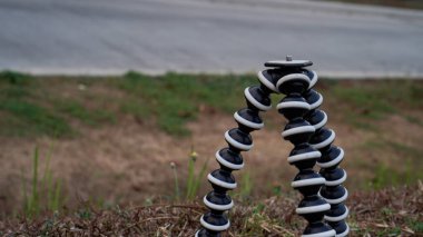 Çimlerin üzerinde duran tripodun yakın görüntüsü. 