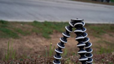 Çimlerin üzerinde duran tripodun yakın görüntüsü. 