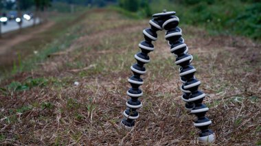 Çimlerin üzerinde duran tripodun yakın görüntüsü. 