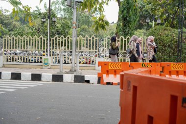 Tangerang, Banten. 14 Ekim 2023 - insanlar kaldırımda turuncu ulaşım servis engelleriyle yürüyorlar..