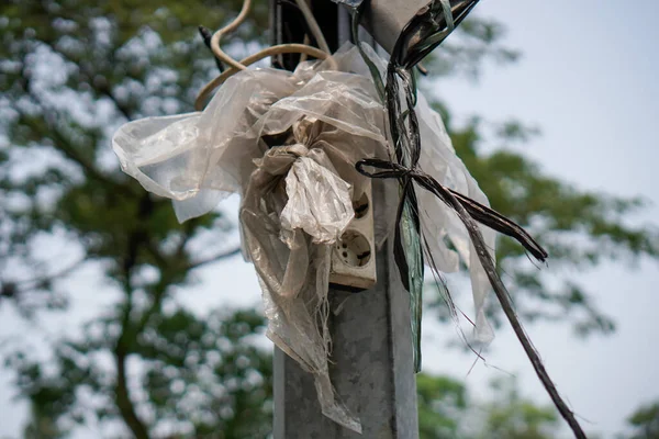 The electrical socket is wrapped in plastic, located on an electrical stand to protect it from rainwater.Format Foto