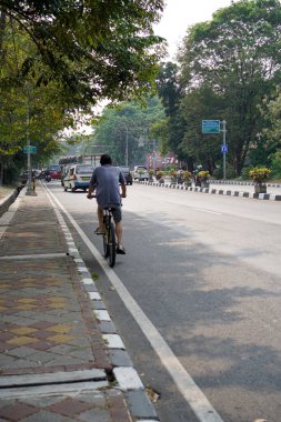 Tangerang, Banten. 14 Ekim 2023, Endonezya. Yetişkin bir adam otoyolda bisiklet sürüyor. Arkadan görünüyor