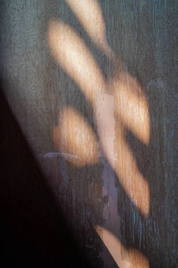 Güneş ışığı pencerelerden eve girer, ahşap duvarların yüzeyine gölgeler bırakır.. 