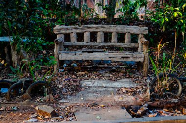 bench in an unkempt garden, seen from the front from a parallel perspective.  clipart