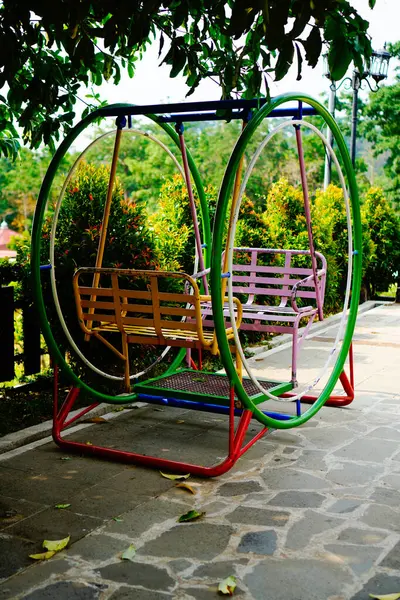 a circular iron swing with a natural panorama background.