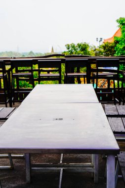 Tepelik bir arkaplan karşısında güzel bir kafe masasının yakın görüntüsü. 