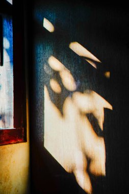 Güneş ışığı pencerelerden eve girer, ahşap duvarların yüzeyine gölgeler bırakır.. 