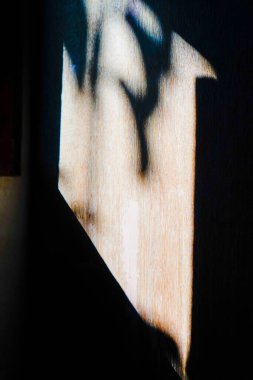 Güneş ışığı pencerelerden eve girer, ahşap duvarların yüzeyine gölgeler bırakır.. 