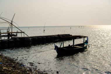 Öğleden sonra sahile dayanan bir tekne, arka planda gökyüzüne karşı yakından görülüyor. 
