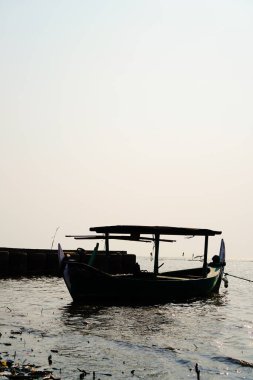 Öğleden sonra sahile dayanan bir tekne, arka planda gökyüzüne karşı yakından görülüyor. 