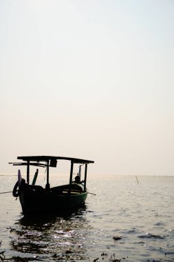 Öğleden sonra sahile dayanan bir tekne, arka planda gökyüzüne karşı yakından görülüyor. 
