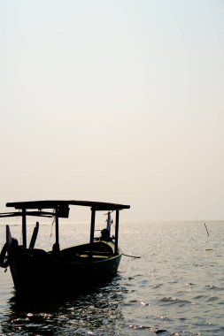Öğleden sonra sahile dayanan bir tekne, arka planda gökyüzüne karşı yakından görülüyor. 