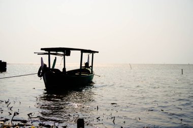 Öğleden sonra sahile dayanan bir tekne, arka planda gökyüzüne karşı yakından görülüyor. 