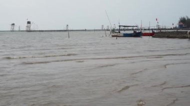 Öğleden sonra sahile dayanan bir tekne, arka planda gökyüzüne karşı yakından görülüyor. 
