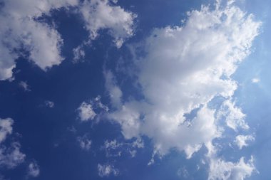 Mavi gökyüzündeki beyaz bulutlardan güzel görünüyor. 
