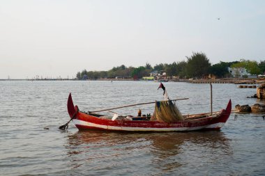 Öğleden sonra sahile dayanan bir tekne, arka planda gökyüzüne karşı yakından görülüyor.