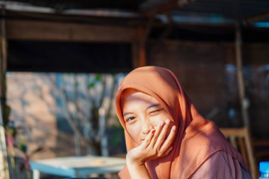 Avucunun içinde çenesini dinlendiren güzel bir kadının yakın plan görüntüsü. 