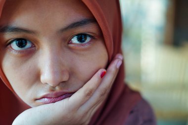 Avucunun içinde çenesini dinlendiren güzel bir kadının yakın plan görüntüsü. 