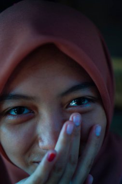 Avucunun içinde çenesini dinlendiren güzel bir kadının yakın plan görüntüsü. 