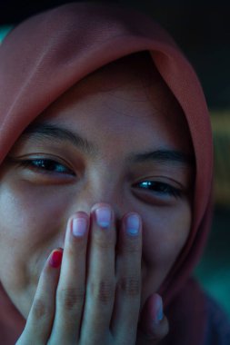 Avucunun içinde çenesini dinlendiren güzel bir kadının yakın plan görüntüsü. 