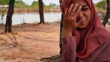 Kurak mevsimin arka planında tesettür takan bir Cava kadınının güzel görünüşü. 
