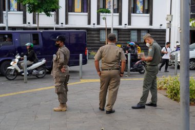 Jakarta Eski Şehir, 19 Aralık 2023 Eski Jakarta şehrinde araç trafiğini kontrol eden PP Satpol 'den uzak görünüyor..