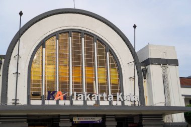 Jakarta Eski Şehir, 19 Aralık 2023. Tren istasyonunun önünden geçen insanlar..