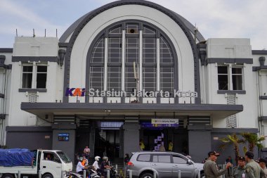Jakarta Eski Şehir, 19 Aralık 2023. Tren istasyonunun önünden geçen insanlar..