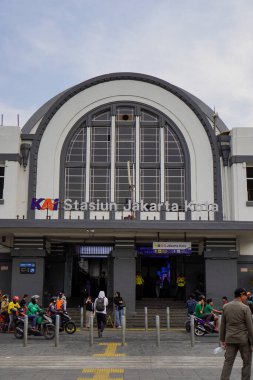 Jakarta Eski Şehir, 19 Aralık 2023. Tren istasyonunun önünden geçen insanlar..