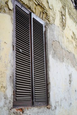 Duvarları soyulmaya başlayan bir binanın penceresinden yakın bir görüntü 