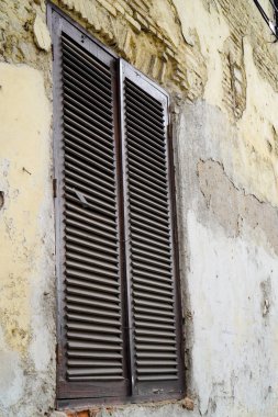 Duvarları soyulmaya başlayan bir binanın penceresinden yakın bir görüntü 