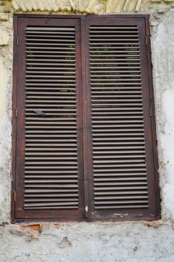 Duvarları soyulmaya başlayan bir binanın penceresinden yakın bir görüntü 