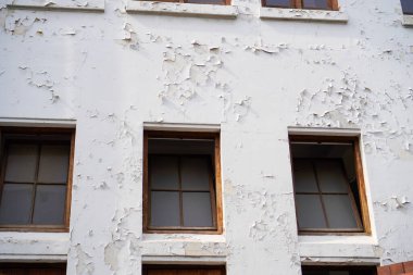 Binanın camlarından yıpranmış gibi görünüyor. 