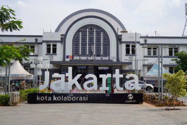 Jakarta Eski Şehir, 19 Aralık 2023. Tren istasyonunun önünden geçen insanlar.. 