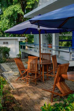 Bahçe sandalyelerini ve şemsiyeli masayı kapat. 